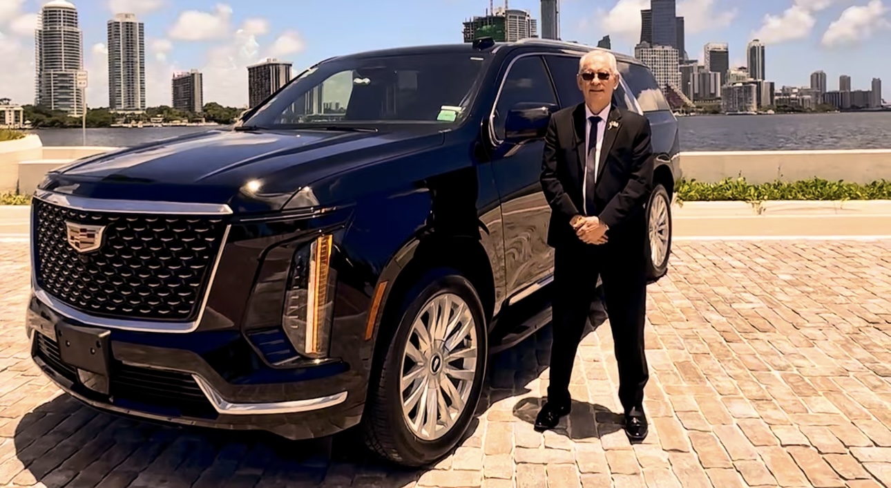 Fabio standing beside the black Cadillac Escalade with the Miami skyline in the background